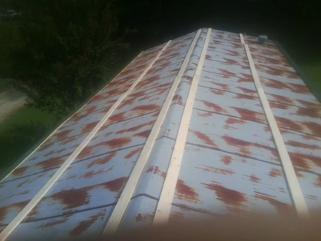 Rusted metal roof panels with new wood purlins before replacement — Storm Damage Roof Repair in Louisa by Roofing Brothers