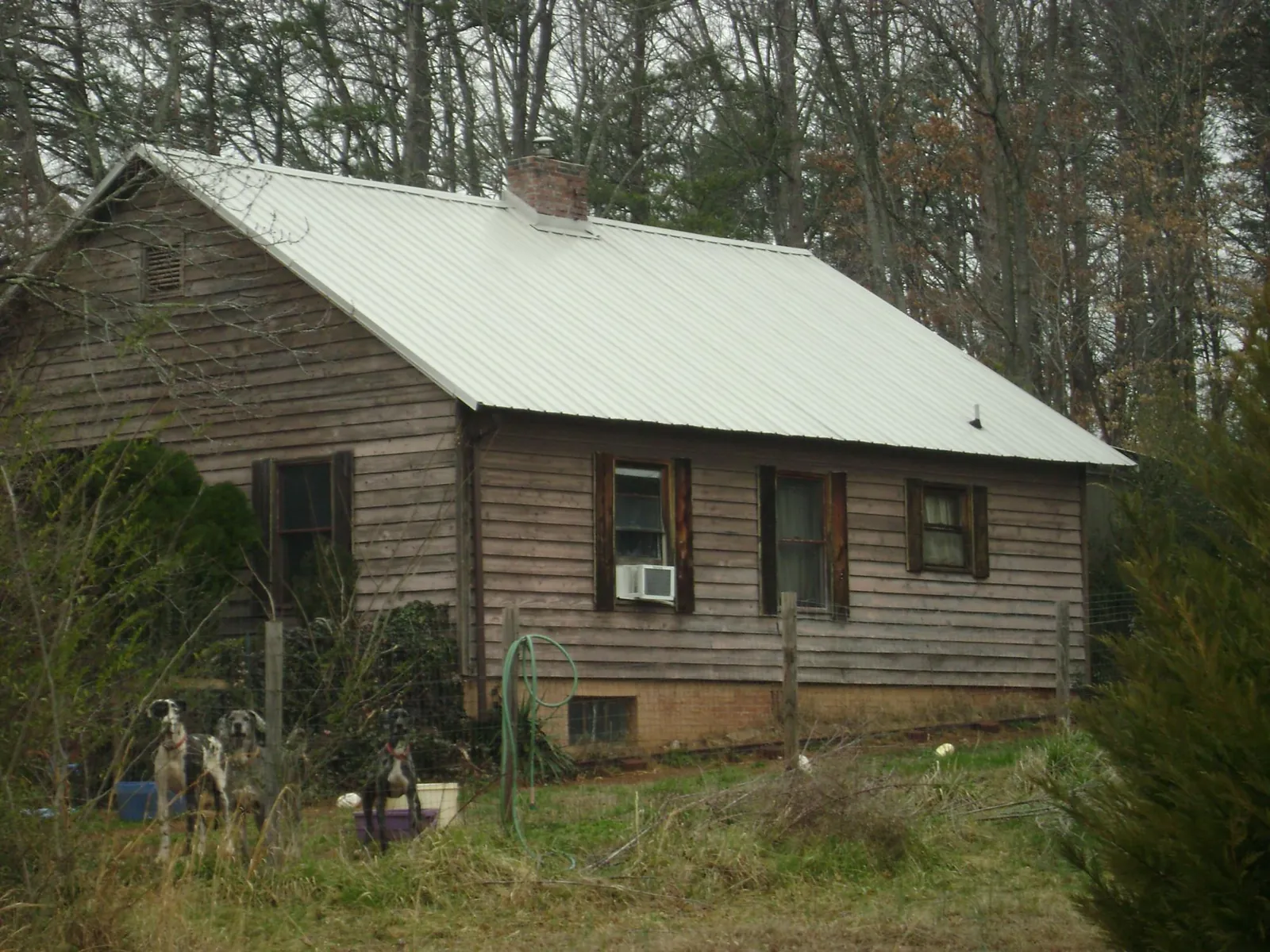 White metal roof on an old wood sided farmhouse, from a Metal Roof Installation job in Louisa